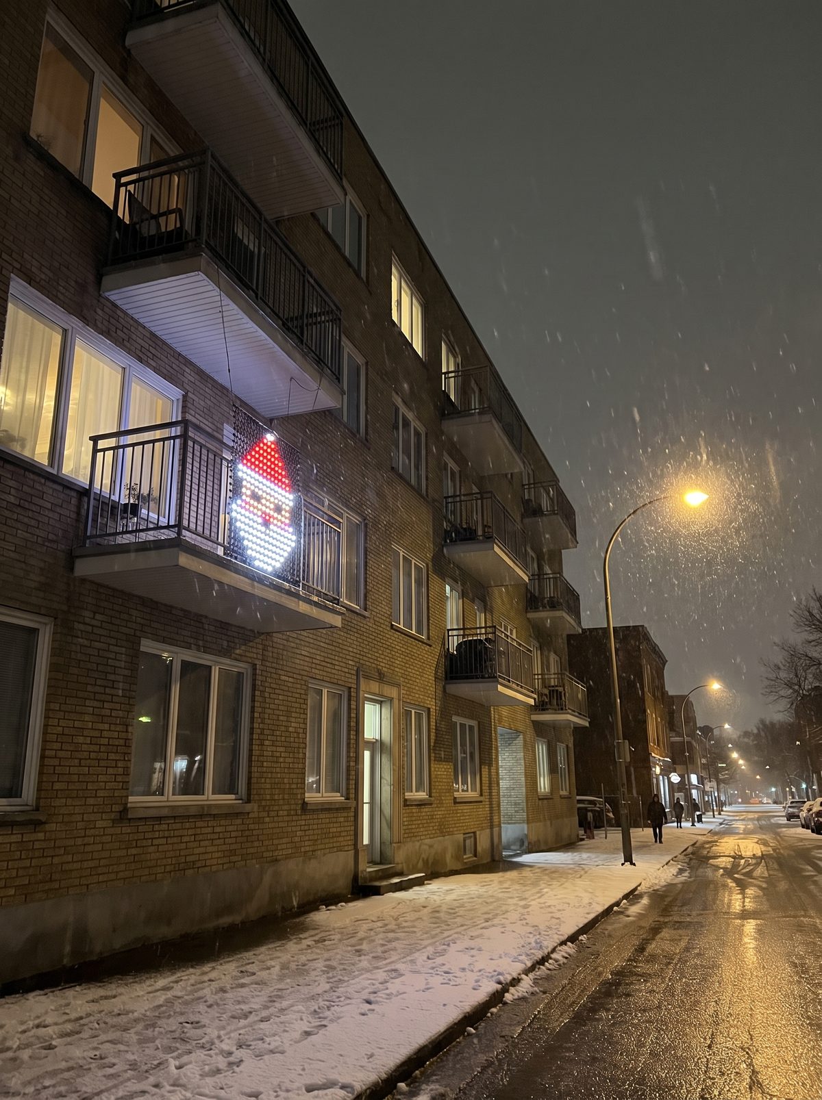 Santa made of 400 LED dots on a second-floor balcony on a snowy night